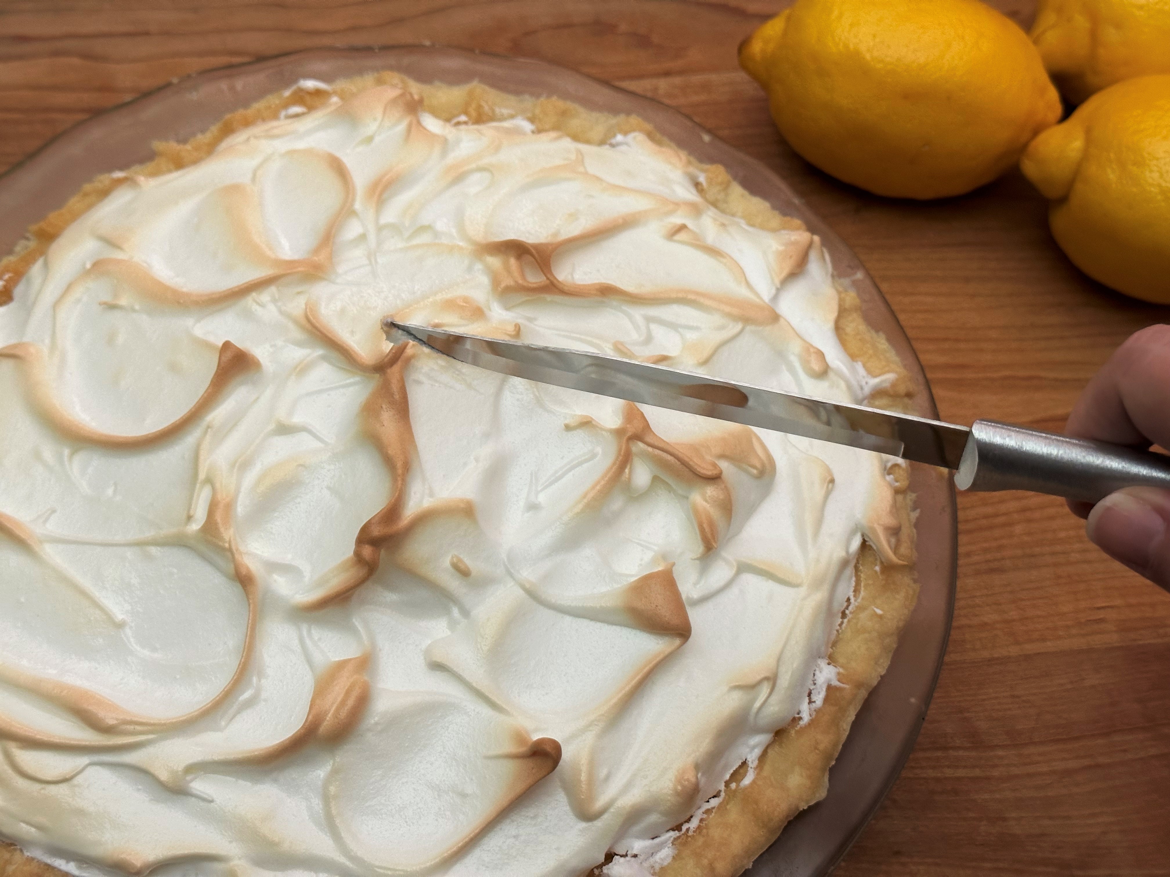 Slicing a lemon meringue pie