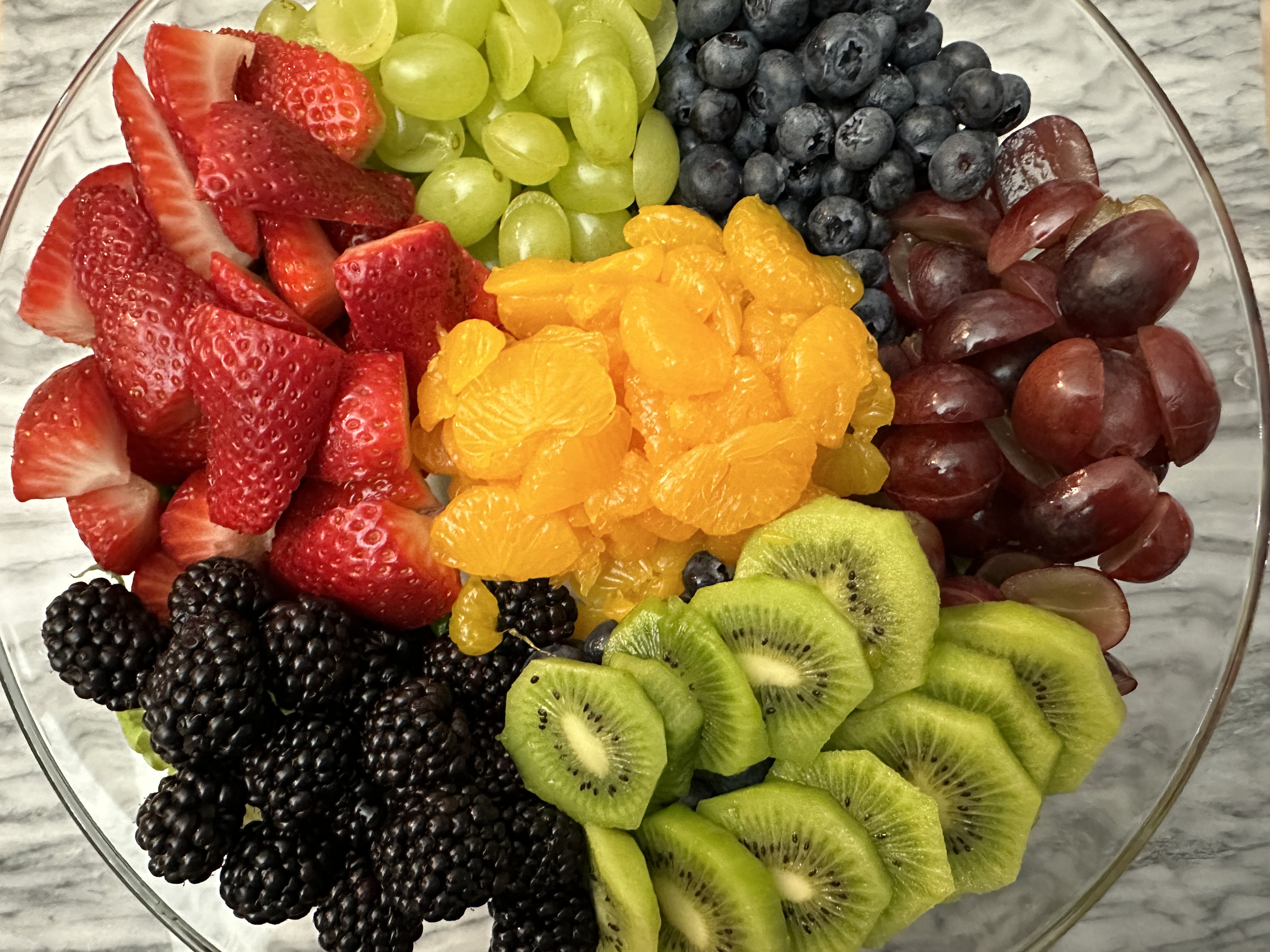 Large bowl with fruits arranged by individual type.