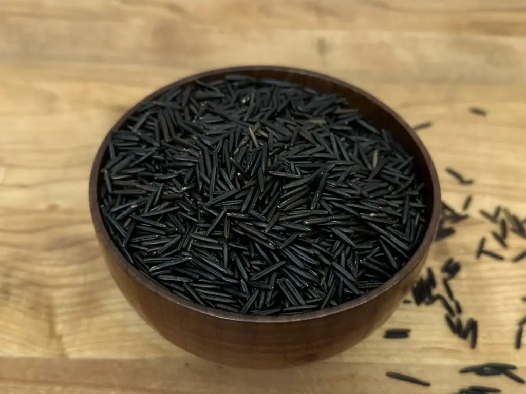 Black Wild Rice in a small wooden bowl.