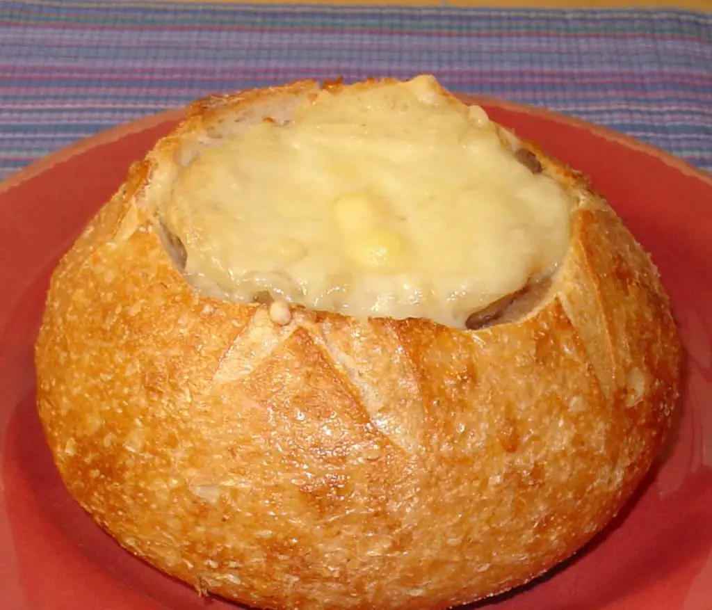 French onion soup being ladled into a bowl