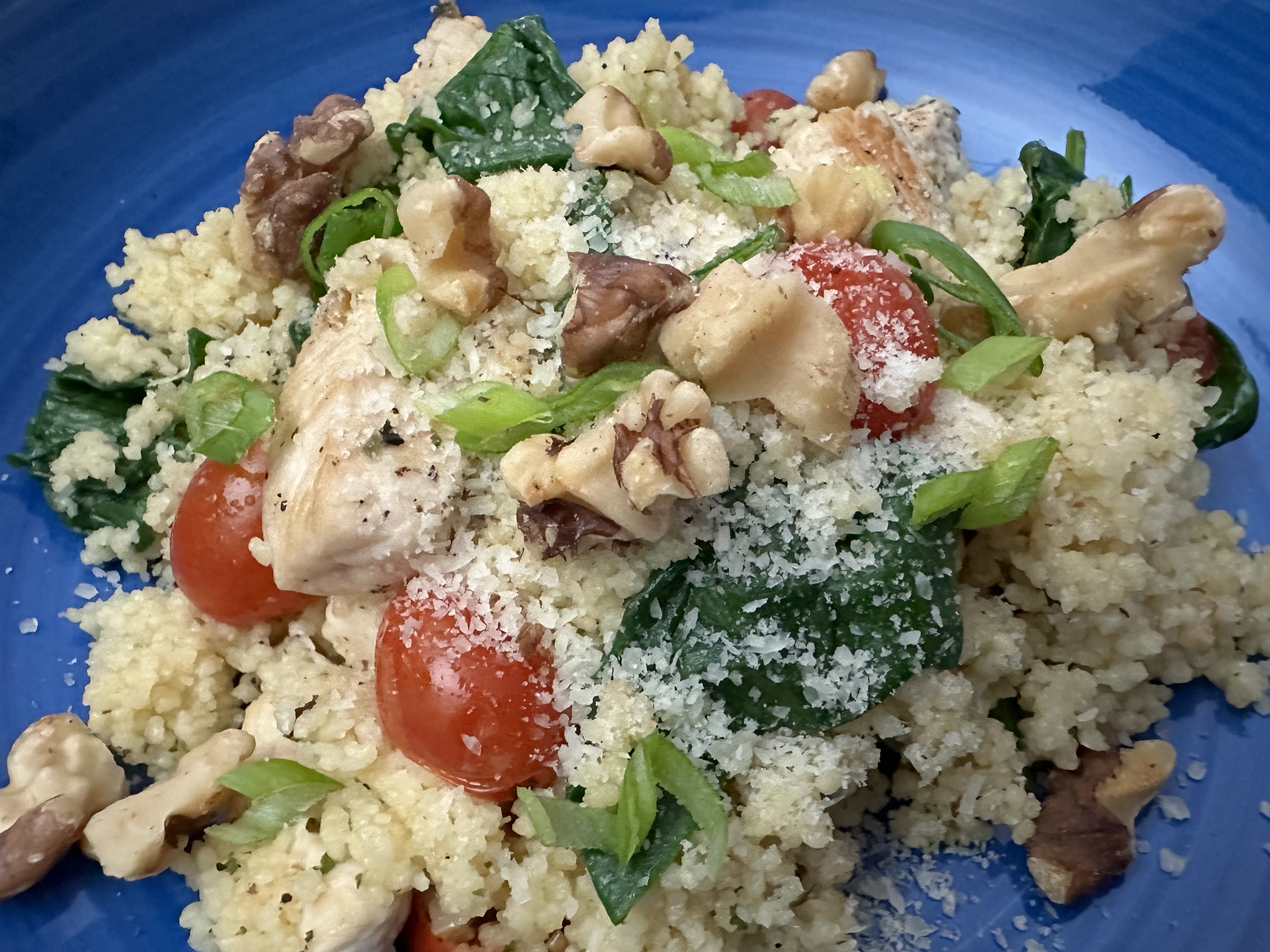 Parmesan Chicken Couscous with spinach, cherry tomatoes, and toasted walnuts.